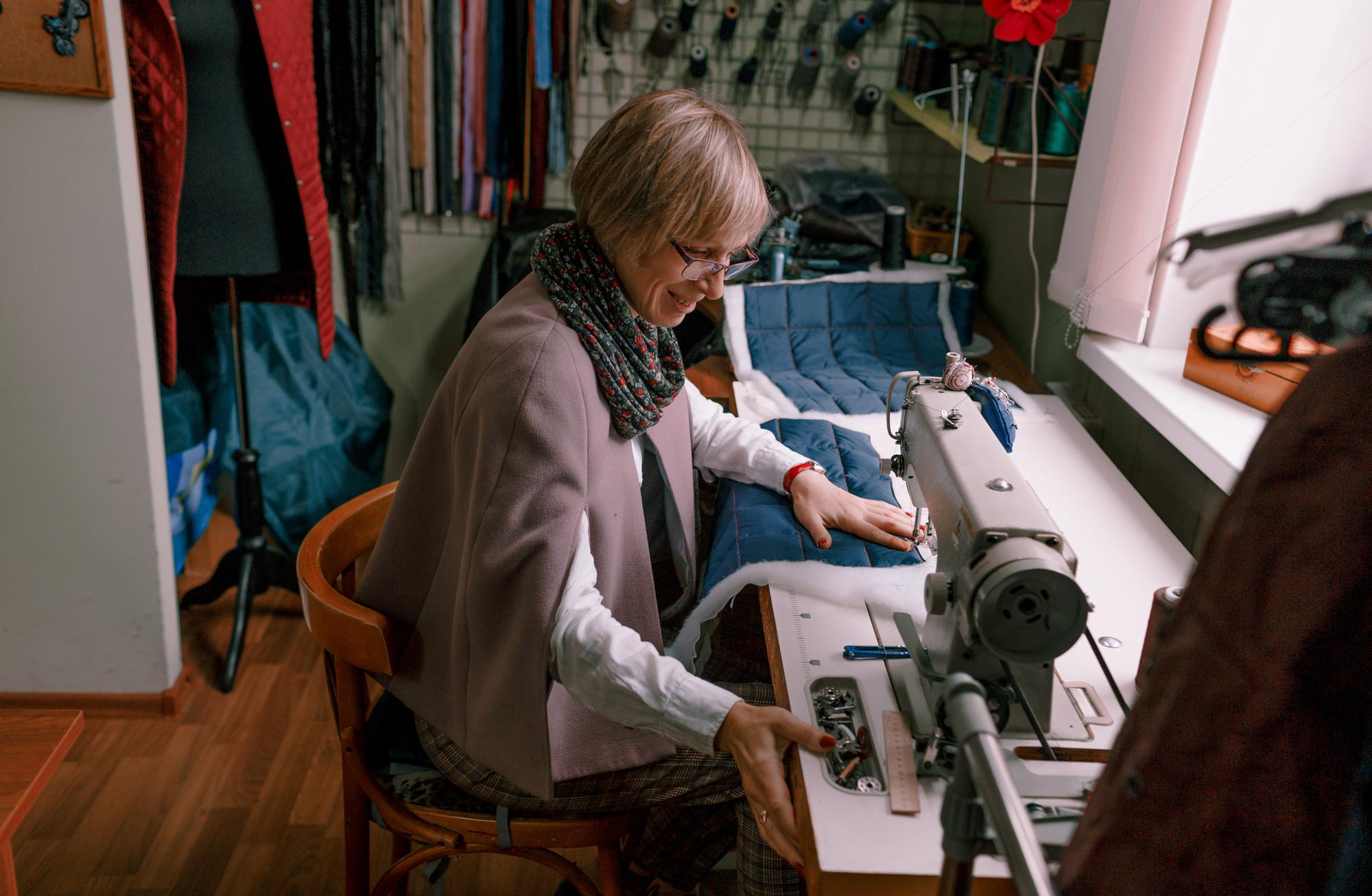 Founder at embroidery machine in bright studio